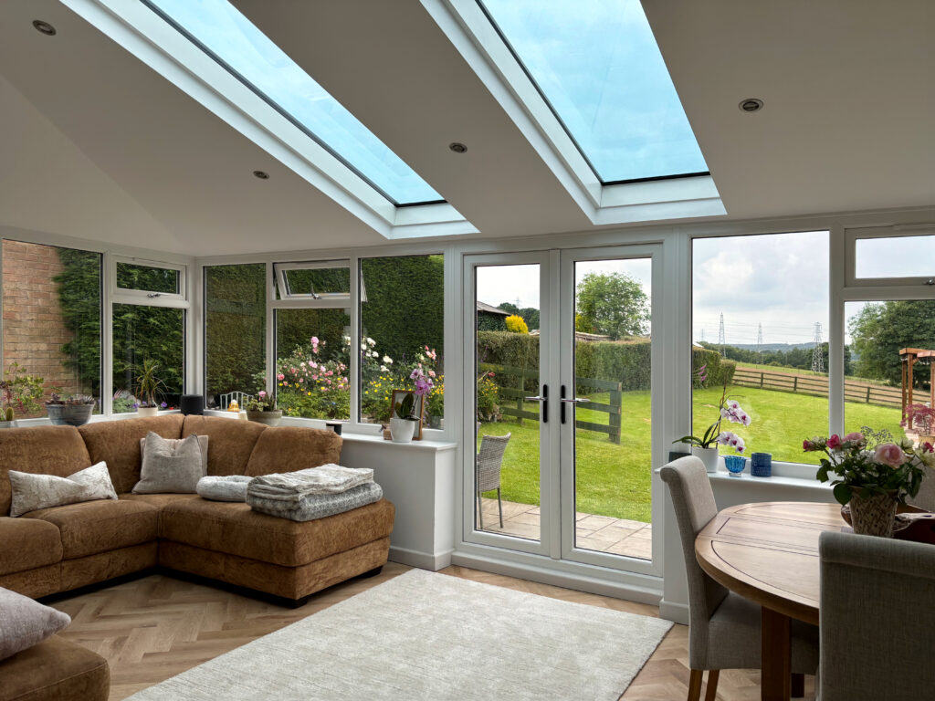 An interior view of a living room conservatory extension featuring SupaLite SkyVista glass panels. 