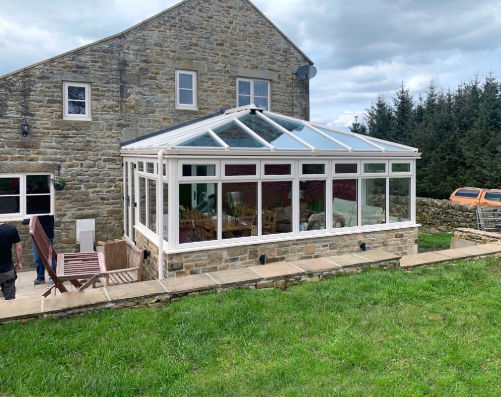 white upvc conservatory by a cottage