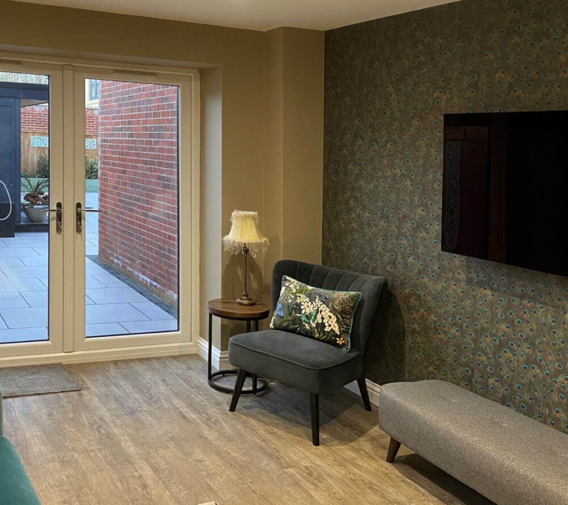 inside of a garage conversion with white upvc french doors leading into the garden area